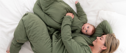Mamma e bambino sono sdraiati sul letto nei sacchi nanna verdi.